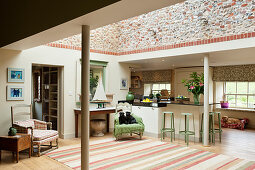 Open plan kitchen living area with a large striped rug