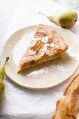 A slice of tart with poached pears and almond frangipane