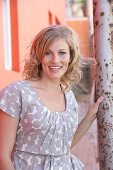 A blonde woman wearing a grey spotted blouse