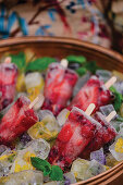 Champagne and berry popsicles on edible flower ice cubes