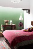 Double bed in the bedroom with green wall