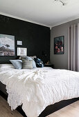 Double bed in bedroom with dark walls