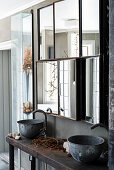 Vintage washstand with metal basins below mirrored cabinets in bathroom