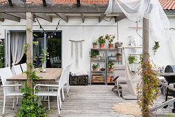 Gemütliche Terrasse mit Pergola und Holzboden am Haus
