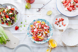 Variety of raw fresh summer salads with fruits and berries