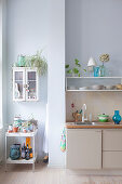 Small wall-mounted cabinet and shelves in niche next to kitchen counter