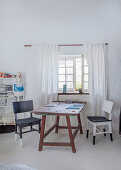 Wooden table and two chairs next to lattice window