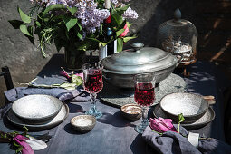 Tablecloth setting with artichokes, flowers and red wine