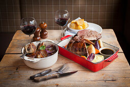 Roast pork and braised marrow bones on a rustic wooden table