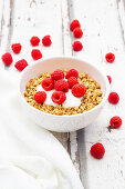 Granola mit Joghurt und Himbeeren im Schälchen