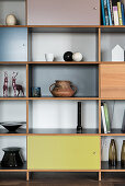 Minimalist decoration on shelving with compartment doors in various colours