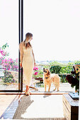 Blonde Frau und Hund auf sonniger Terrasse