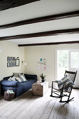 Rocking chair and blue sofa in simple, rustic living room