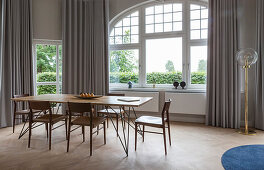 Esstisch mit Holzplatte und Stühle vor Fenster in Altbauwohnung