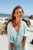 A brunette woman wearing a light-blue beach dress by the sea