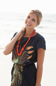 A young blonde woman with necklace wearing a beach dress