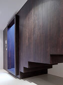 Staircase boxed in with dark wood