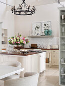 Bowl of flowers on island counter in bright country-house kitchen
