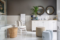 Pale furnishings and dark walls in elegant bathroom