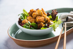 Diced tofu with a spicy cornflake coating on a bed of salad