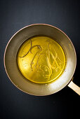 Olivenöl mit Zitronenzesten in Pfanne