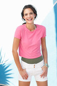 A young woman wearing a pink t-shirt and white shorts