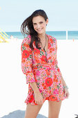A young woman on a beach wearing a floral dress