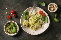 Classic italian spaghetti pasta with pesto sauce, pine nuts, olive oil and fresh basil