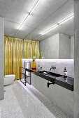 Grey, modern bathroom with indirect lighting on mirrored wall