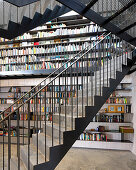 Self-supporting staircase made from perforated metal in front of bookcase