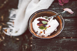 Pavlova with whipped cream and spiced plums in cider