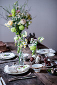 A table laid for Easter with spring flowers and chocolate eggs