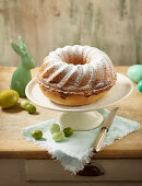 A marble Bundt cake dusted with icing sugar with Easter decorations