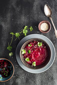 Beetroot soup in a bowl with sesame seeds and coriander