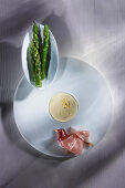 Green asparagus served with ham and sauce Hollandaise