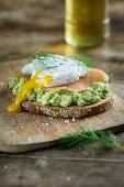 Bread topped with avocado cream, salmon and a poached egg