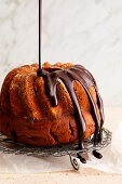 Chocolate glaze being poured over a Bundt cake