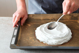 Meringue being spread on a baking tray for a pavlova