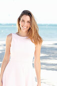 Junge Frau in hellem Kleid am Strand