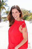 A brunette woman outside wearing a red top