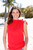 A brunette woman outside wearing a red top