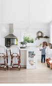 Kinder und Hund in heller weißer Küche mit Barstühlen an Kücheninsel
