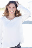 A young woman wearing a white long-sleeved blouse