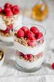 Müsli mit griechischem Joghurt und Himbeeren im Glas