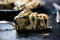 Ein Stück veganer, mit Spinat und Walnüssen gefüllter Hefeschneckenkuchen
