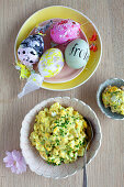 Eiersalat mit frischem Schnittlauch und verzierte Eier zu Ostern