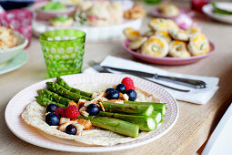 Roasted green asparagus with berries and croutons on a tortilla