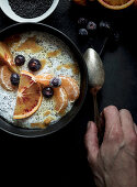 Chia seeds pudding with slices of orange, mandarins and olives in bowl