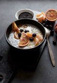 Chia seeds pudding with slices of orange, mandarins and olives in bowl
