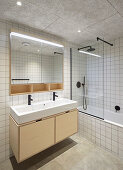 Badezimmer mit weißen Wandfliesen und Betonboden